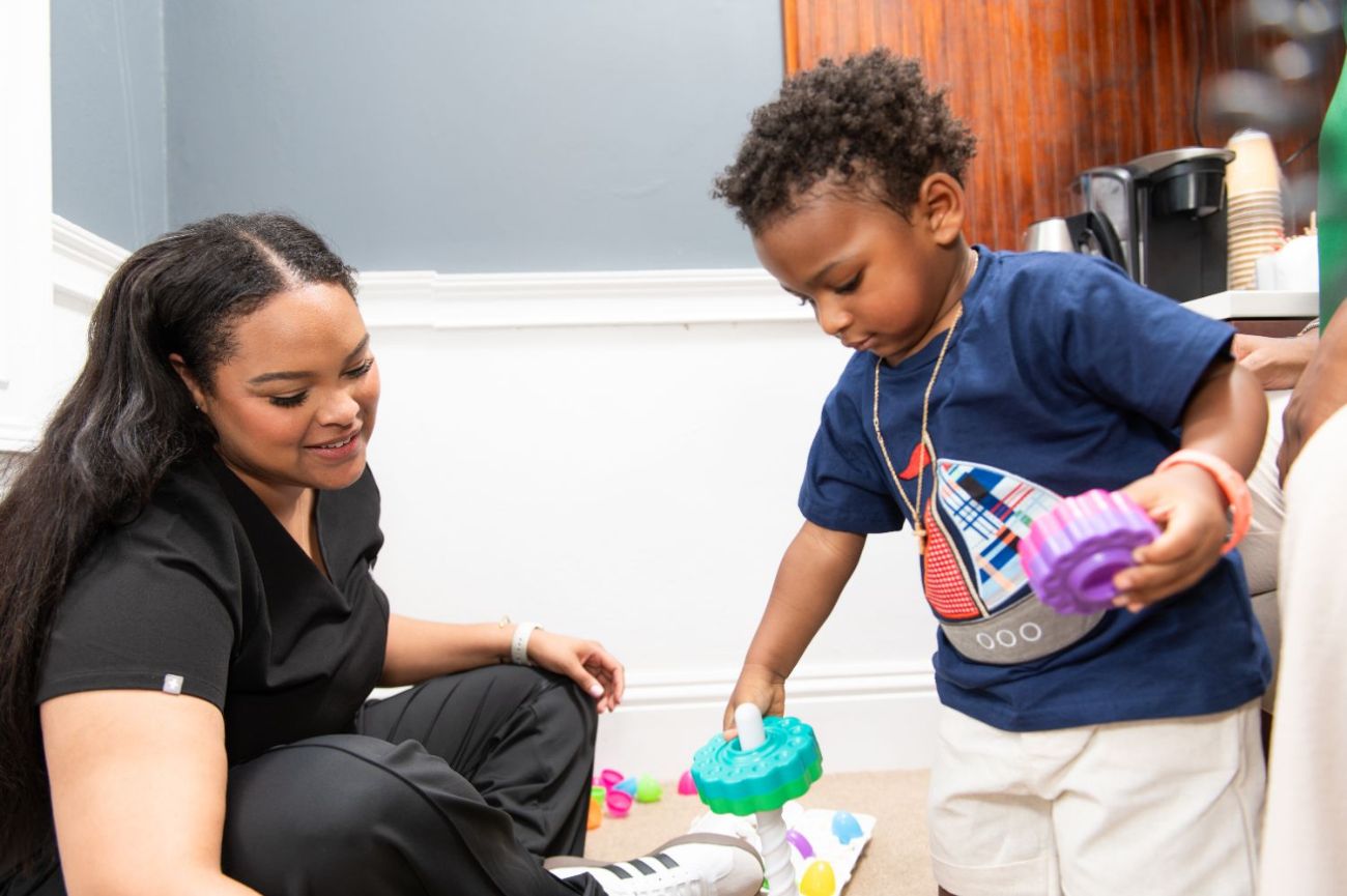 A therapist working on the floor with a toddler